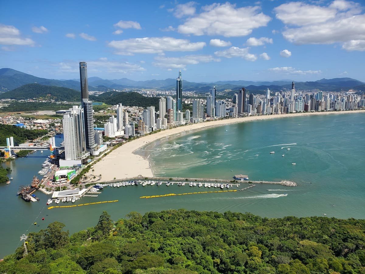Vista elevada da Praia Central de Balneário Camboriú, com prédios altos acompanhando a orla. Ilustrando artigo Orla de Balneário Camboriú: por que tantos prédios altos?