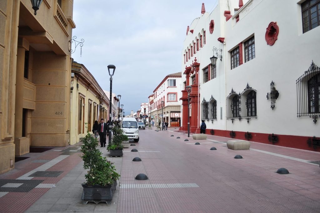 Rua do centro histórico de La Serena com fachadas alinhadas e torres ao fundo. Ilustrando artigo Centro de La Serena: por que parece mais antigo do que é?
