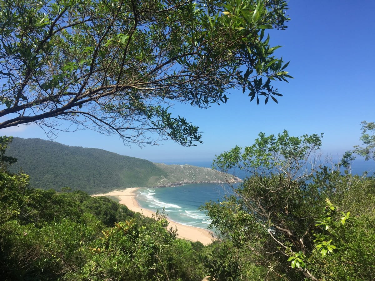 Praia da Lagoinha do Leste entre morros, com lagoa e vegetação atrás da areia. Ilustrando artigo Praias de Santa Catarina: como os morros moldam a costa?