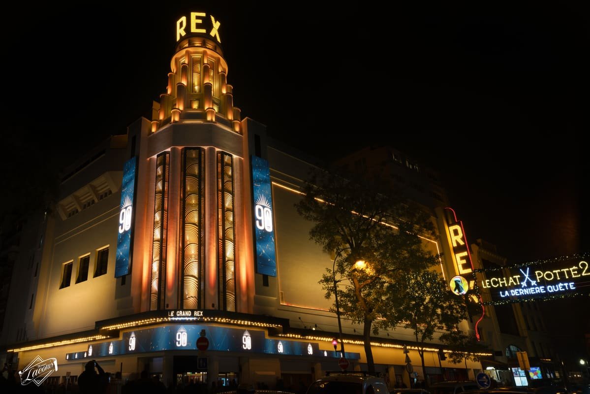 Fachada iluminada do Grand Rex à noite, com letreiro e faixas comemorativas de 90 anos. Ilustrando artigo Noite em Paris: por que alguns bairros concentram movimento?