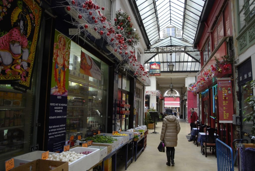 Lojas, produtos e pedestres sob a cobertura de vidro do Passage Brady. Ilustrando artigo Paisagens de Paris: por que são tão diferentes?