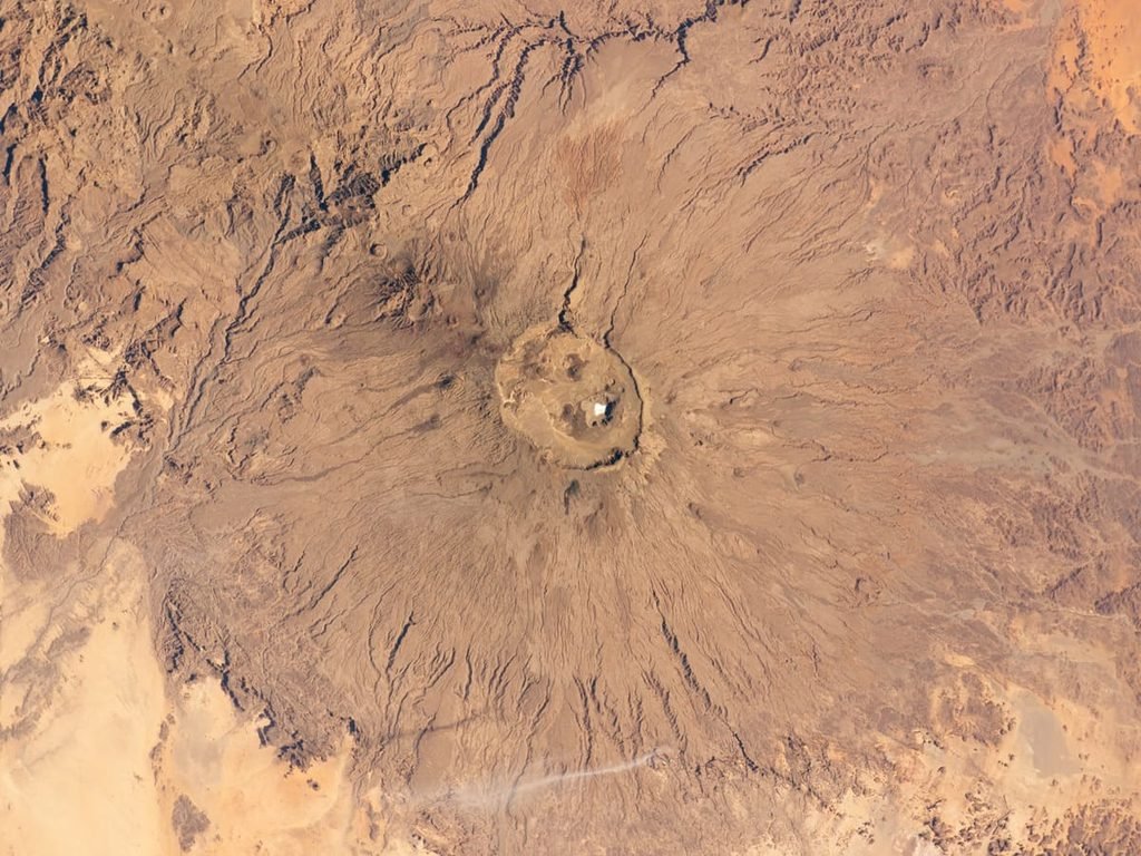 Vista orbital de Emi Koussi, com depressões no topo e encostas amplas no deserto do Chade. Ilustrando artigo Círculos na África: por que nem todos são crateras?