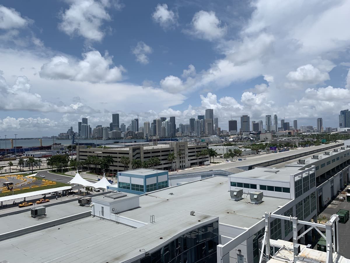 Instalações do porto de Miami em primeiro plano, com água e uma sequência de edifícios altos ao fundo, ilustrando artigo Miami: o que explica os contrastes da paisagem urbana?