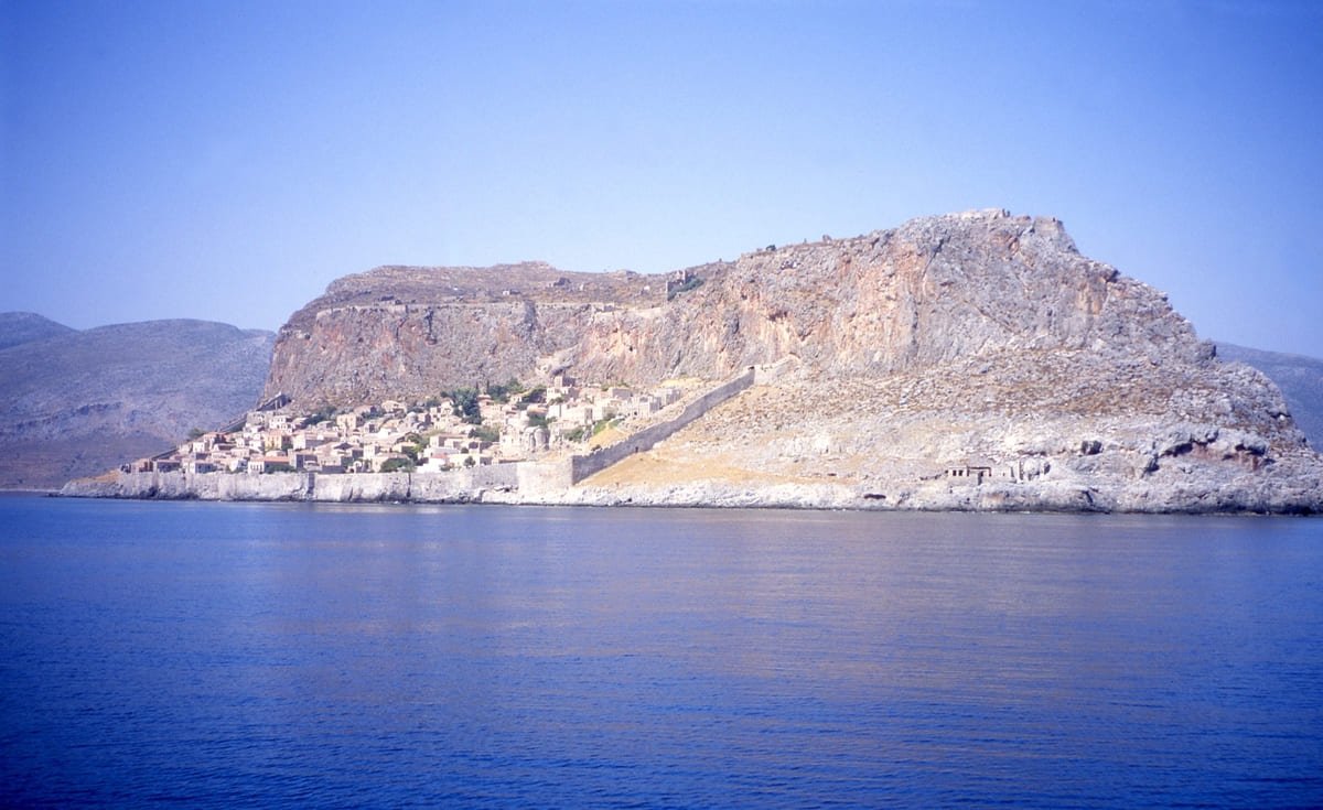 Cidade baixa de Monemvasia entre o mar e uma escarpa rochosa, na Grécia. Ilustrando artigo Cidades fortificadas: como o terreno muda a visita?