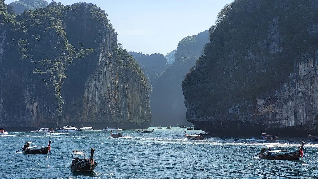 Paisagem natural composta por Torres Calcárias na orla de Maya Bay, barcos com turistas e/ou pescadores navegando pelo mar. O impacto ambiental como consequência das filmagens, é uma das curiosidades sinistras sobre o filme A Praia.