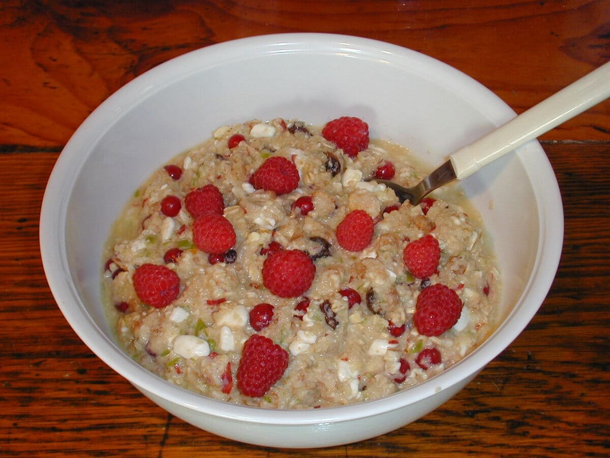 Müesli preparado com flocos de aveia e frutas, coberto com framboesas.