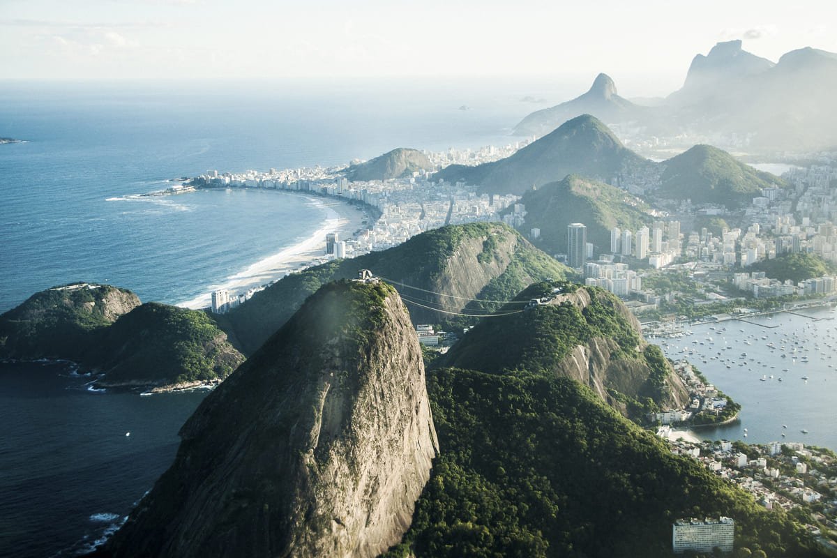 Vista aérea de encostas florestadas do Parque Nacional da Tijuca e áreas urbanizadas ao redor. Ilustrando artigo Áreas verdes do Rio: como essas paisagens se formaram?